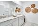 Bright bathroom featuring double vanity sinks with granite countertops and decorative wall accents at 7396 Capstone Dr, Groveland, FL 34736
