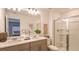 Modern bathroom featuring double sinks, white countertops, a spacious shower, and neutral-toned cabinetry at 7605 Waterscape Dr, Groveland, FL 34736