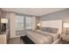 This bedroom features a neutral color palette, two large windows and tasteful décor at 7605 Waterscape Dr, Groveland, FL 34736