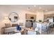 Inviting living area with contemporary furnishings, a large round mirror, and an open-concept kitchen at 7605 Waterscape Dr, Groveland, FL 34736
