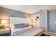 Calming main bedroom with gray walls, a plush bed, bedside tables, and a glimpse into the walk-in closet at 7605 Waterscape Dr, Groveland, FL 34736