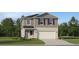 Charming two-story home with gray siding, lush landscaping, and a two-car garage at 958 Hour Glass Rd, Lakeland, FL 33801