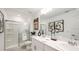 This modern bathroom features double sinks, and a tiled shower with glass doors at 2569 Penguin Blvd, Davenport, FL 33837