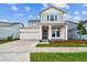 Inviting two-story home with modern design, manicured lawn, attached garage, and covered front porch at 3092 Expedition Dr, St Cloud, FL 34771