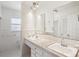 Bathroom features double sinks with a marble-look countertop, framed by a large mirror and bright vanity lighting at 1841 5Th Se St, Winter Haven, FL 33880