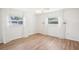 Bright bedroom featuring wood-look floors, two windows with sheer white curtains, and a ceiling fan at 1841 5Th Se St, Winter Haven, FL 33880