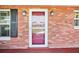 Front door with a brick exterior, two sconces and a storm door at 1841 5Th Se St, Winter Haven, FL 33880
