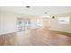 Bright living room with wood floors, sliding doors to enclosed patio, and view of kitchen at 1841 5Th Se St, Winter Haven, FL 33880
