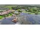 An aerial view shows the pool and clubhouse along a lake with a covered dock at 474 Del Sol Ave, Davenport, FL 33837