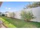 The backyard features a well-maintained lawn, a white fence, and some greenery at 474 Del Sol Ave, Davenport, FL 33837