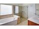 Bathroom with a glass shower, soaking tub, and double vanity, offering modern amenities at 474 Del Sol Ave, Davenport, FL 33837