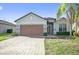 Charming single-story home with a paver driveway, two-car garage, and well-maintained landscaping at 474 Del Sol Ave, Davenport, FL 33837