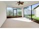 The carpeted screened lanai has large windows and a ceiling fan at 474 Del Sol Ave, Davenport, FL 33837