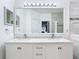 Bathroom featuring double sinks, vanity, light fixtures, and a large framed mirror at 14110 Sapphire Bay Cir, Orlando, FL 32828