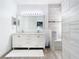 Bright bathroom featuring a double vanity, large mirror, and tiled shower with a bench at 14110 Sapphire Bay Cir, Orlando, FL 32828