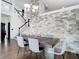 Dining room with wood floors, exposed brick wall, a chandelier and a modern wood table with glass legs at 14110 Sapphire Bay Cir, Orlando, FL 32828