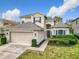 Attractive two-story home featuring a well-maintained lawn, manicured landscaping, and a two-car garage at 14110 Sapphire Bay Cir, Orlando, FL 32828