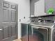 Contemporary laundry room complete with modern appliances and black accent wall at 14110 Sapphire Bay Cir, Orlando, FL 32828