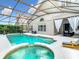 Screened pool with integrated spa, lush greenery and shaded seating area under string lights at 14110 Sapphire Bay Cir, Orlando, FL 32828