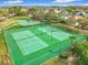 Aerial view of well-maintained tennis courts with lush green landscaping and fencing for active recreation at 14110 Sapphire Bay Cir, Orlando, FL 32828