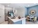 This kitchen features an island, grey cabinetry, stainless steel appliances, and a dining area at 2557 Penguin Blvd, Davenport, FL 33837