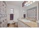 Bright bathroom featuring a vanity with granite top, patterned shower curtain, and dual windows at 4089 Lehman Ln, Lakeland, FL 33813