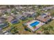 Aerial view of community pool with surrounding houses, palm trees, and green space at 540 Buckingham Cir, Davenport, FL 33897