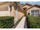 Inviting home exterior with a well-manicured lawn, manicured hedges, and bright yellow front door at 540 Buckingham Cir, Davenport, FL 33897