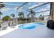 Relaxing screened-in pool area with clear blue water, white deck and comfortable chairs at 540 Buckingham Cir, Davenport, FL 33897