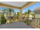 View from a tiled balcony, showcasing the neighborhood with lush tropical landscaping and blue skies at 1529 Euston Dr, Reunion, FL 34747