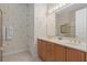 Bathroom featuring a double vanity, a shower, and light patterned wallpaper at 1529 Euston Dr, Reunion, FL 34747