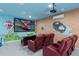 Entertainment space with a projector screen and tiered seating with red leather recliners at 1529 Euston Dr, Reunion, FL 34747