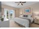 Bright main bedroom boasts a king bed, ceiling fan and access to a balcony at 1529 Euston Dr, Reunion, FL 34747