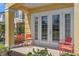 Covered patio with tiled flooring, seating, and French doors, offering outdoor relaxation space at 1529 Euston Dr, Reunion, FL 34747