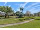 Community playground with green canopy, swings, and benches in a park-like setting with lush greenery at 1529 Euston Dr, Reunion, FL 34747