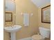 Powder room featuring a pedestal sink, patterned wallpaper and framed artwork at 1529 Euston Dr, Reunion, FL 34747