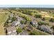 Overhead view of condominium buildings, surrounding mature trees, golf course and road at 7636 Heritage Crossing Way, Reunion, FL 34747