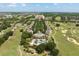 An aerial view showcases the resort, featuring lush landscaping, a pool, and rows of villas for a serene living experience at 7636 Heritage Crossing Way, Reunion, FL 34747