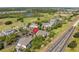 High angle view of condominium buildings, surrounding trees, golf course and road with a red pin at 7636 Heritage Crossing Way, Reunion, FL 34747