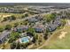 Aerial view showcasing the condominium buildings, surrounding mature trees, and community pool at 7636 Heritage Crossing Way, Reunion, FL 34747