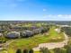 Wide aerial view showcasing the condominium buildings, surrounding mature trees, and community at 7636 Heritage Crossing Way, Reunion, FL 34747