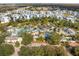 Aerial view showcasing an expansive resort with a large pool area, palm trees, and colorful umbrellas at 7636 Heritage Crossing Way, Reunion, FL 34747