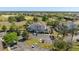 Wide aerial view showcasing the condominium building, parking lot, and surrounding mature trees and golf course at 7636 Heritage Crossing Way, Reunion, FL 34747