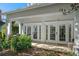 Inviting back patio featuring double french doors, lush landscaping, and ample outdoor seating at 7636 Heritage Crossing Way, Reunion, FL 34747