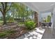 A serene backyard patio with table and chairs overlooking a manicured lawn and lush garden at 7636 Heritage Crossing Way, Reunion, FL 34747