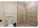 Tiled bathroom featuring a toilet and a glass-enclosed shower area, offering a clean and functional space at 7636 Heritage Crossing Way, Reunion, FL 34747
