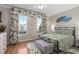 Bedroom featuring palm tree themed curtains, a queen bed, and two windows at 7636 Heritage Crossing Way, Reunion, FL 34747