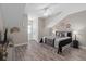 Neutral bedroom features a large bed, wood flooring, and a closet with a window for natural light at 7636 Heritage Crossing Way, Reunion, FL 34747