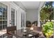 Cozy covered patio with wicker furniture, a glass table, and a view of the lush garden at 7636 Heritage Crossing Way, Reunion, FL 34747