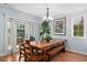 Dining room with wood table, bench seating, and French doors, plus decorous hanging chandelier at 7636 Heritage Crossing Way, Reunion, FL 34747